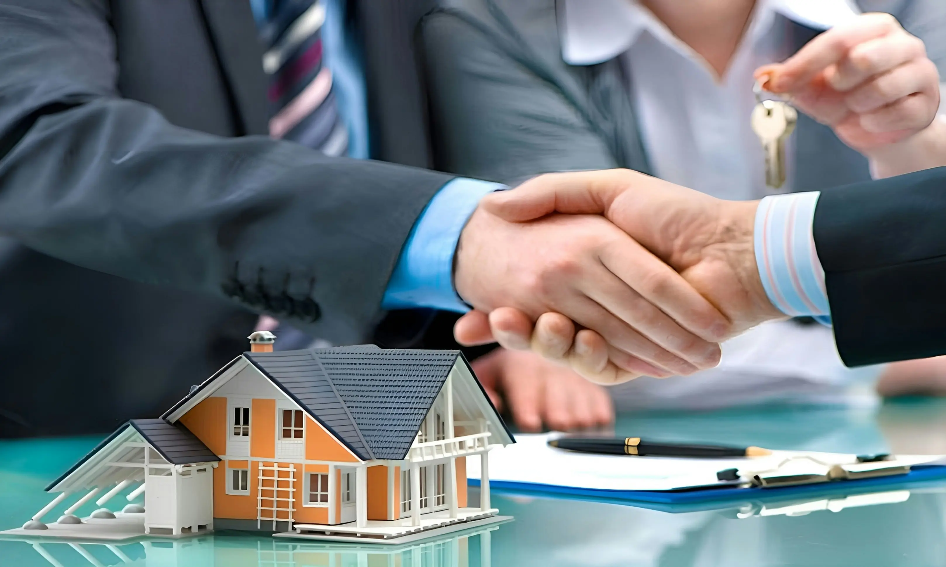 Real estate agent handing over house keys with a handshake